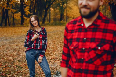 Zarif çift sonbahar parkında vakit geçiriyor.