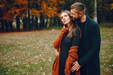 Zarif çift sonbahar parkında vakit geçiriyor.