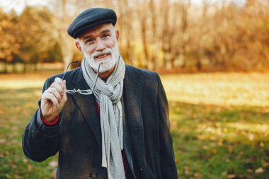Güneşli bir sonbahar parkta zarif yaşlı adam