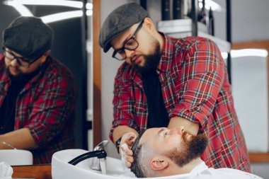 Berber dükkanında oturan şık bir adam.