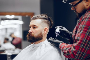 Berber dükkanında oturan şık bir adam.