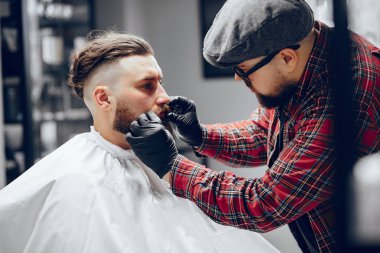 Berber dükkanında oturan şık bir adam.