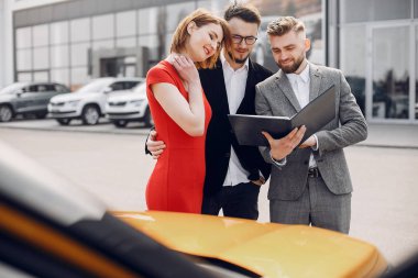 Bir araba galerisinde şık ve zarif bir çift.