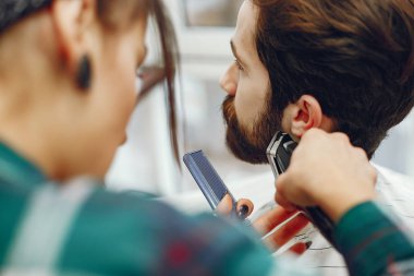 Berber dükkanında oturan şık bir adam.