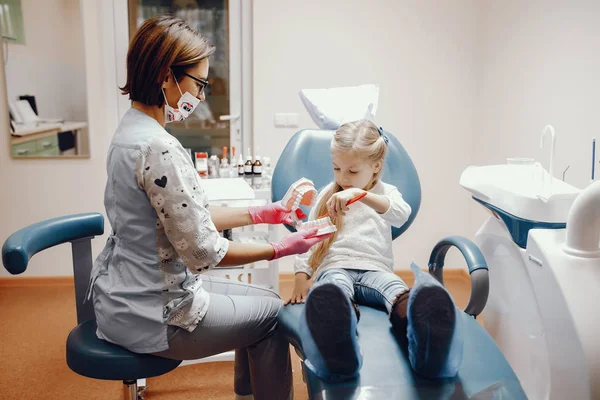 Schattig klein meisje zitten in het kantoor van de tandartsen — Stockfoto