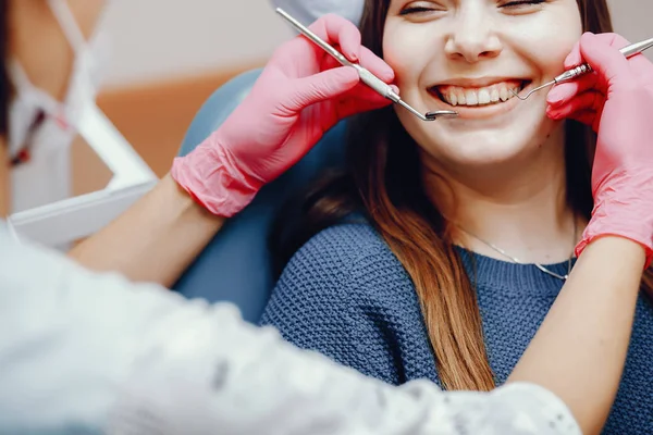 Schöne Mädchen sitzen in der Zahnarztpraxis — Stockfoto