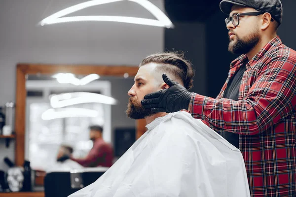 Stilvoller Mann sitzt in einem Friseurladen — Stockfoto