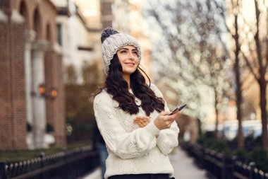 Şehirde beyaz kazak giyen tatlı bir esmer.