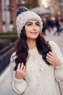 Şehirde beyaz kazak giyen tatlı bir esmer.