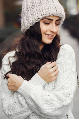 Şehirde beyaz kazak giyen tatlı bir esmer.