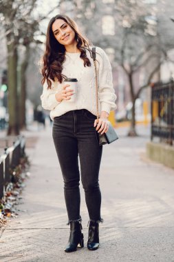 Şehirde beyaz kazak giyen tatlı bir esmer.