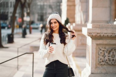 Şehirde beyaz kazak giyen tatlı bir esmer.