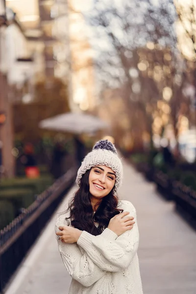 Brune mignonne dans un pull blanc dans une ville — Photo