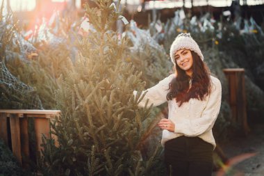 Beyaz süveter ve Noel ağacı içinde tatlı bir esmer.