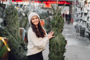 Beyaz süveter ve Noel ağacı içinde tatlı bir esmer.