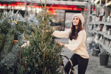 Beyaz süveter ve Noel ağacı içinde tatlı bir esmer.