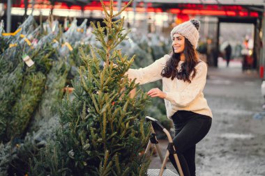 Beyaz süveter ve Noel ağacı içinde tatlı bir esmer.