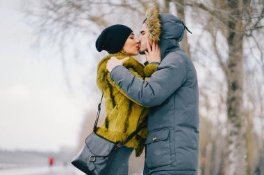 Güneşli bir kış gününde parkta yürüyen mutlu çift.