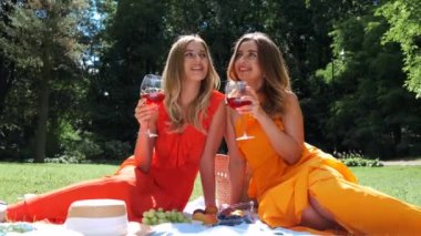 Parkta piknik yapıp şarap içen iki kız