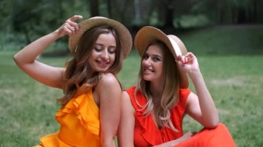 Yaz aylarında dışarıda oturan şapkalı kızların portresi
