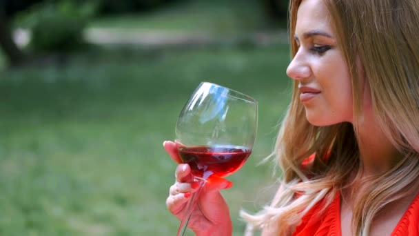 Közel-up a lány szőke haja bort ivott a parkban — Stock videók