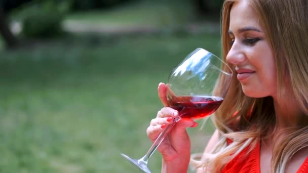 Nahaufnahme von Mädchen mit blonden Haaren, die Wein im Park trinken — Stockvideo