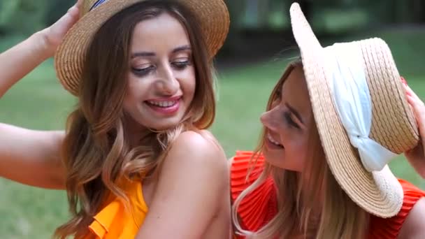 Retrato de chicas con sombreros sentadas afuera en verano — Vídeos de Stock