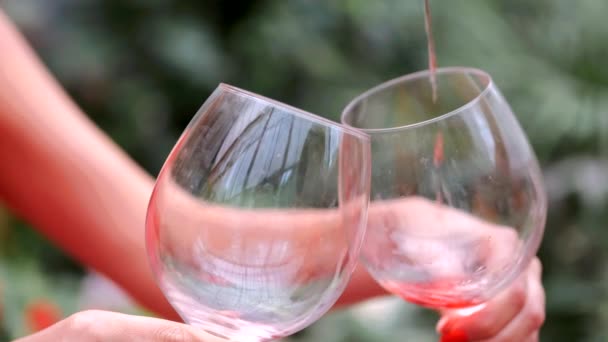 Close-up de mãos segurando copos de vinho no fundo verde — Vídeo de Stock