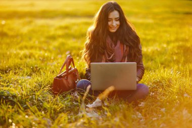 esmer kız parkta onu laptop üzerinde çalışıyor
