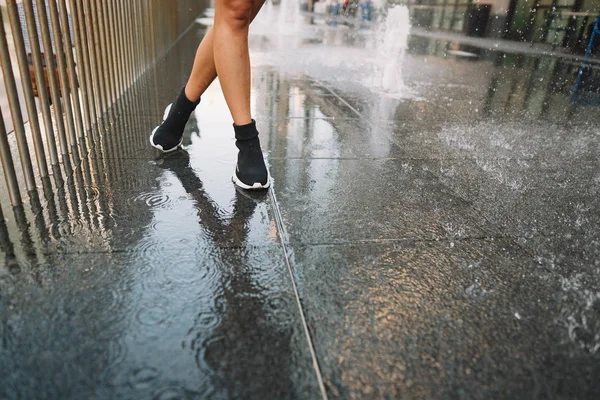 Mädchen spielt und tanzt auf einer feuchten Straße herum — Stockfoto