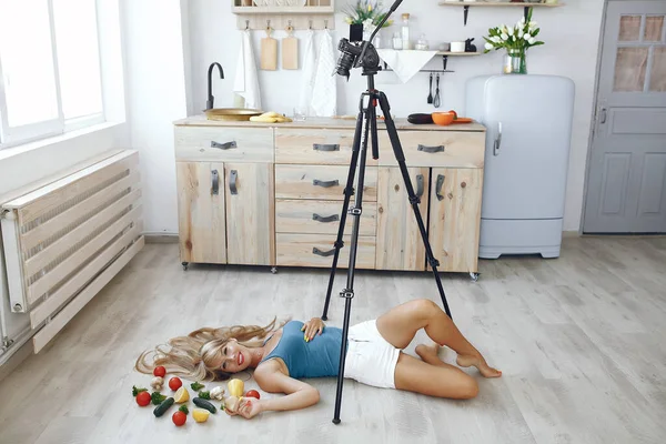 Beautiful and sporty girl in a kitchen recording a video — Stock Photo, Image