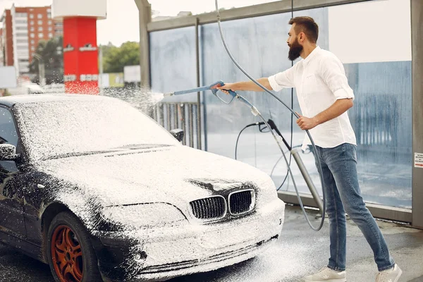 Uomo che lava la sua auto in una stazione di lavaggio — Foto Stock