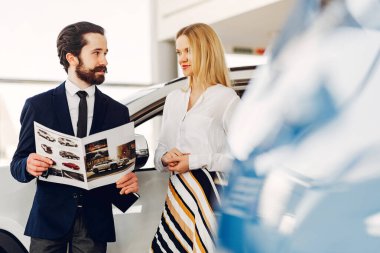 Bir araba galerisinde şık ve zarif bir kadın.