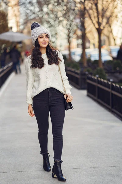 Brune mignonne dans un pull blanc dans une ville — Photo