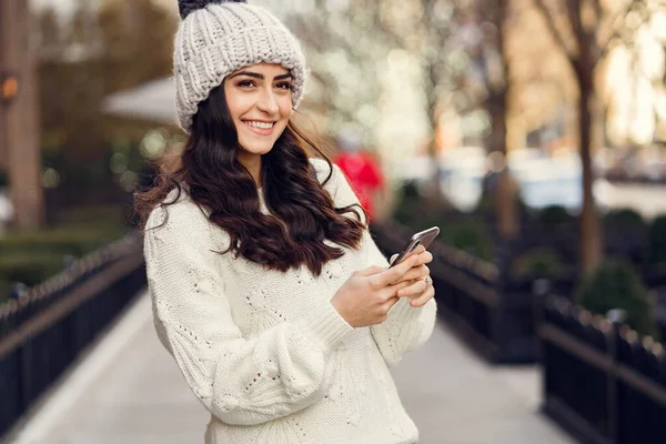 Cute brunetka w białym swetrze w mieście — Zdjęcie stockowe