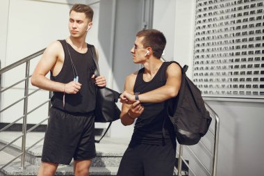 Şehirde duran spor elbiseli yakışıklı adamlar.