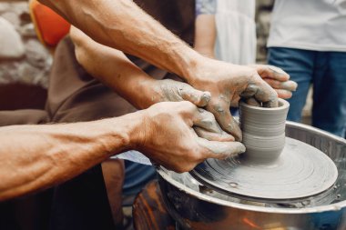 Torunları olan büyükanne çömlekçilikte sürahi yapar