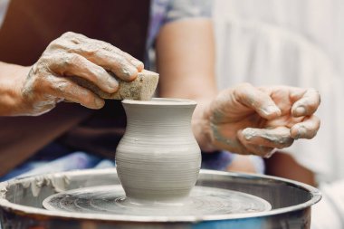 Torunları olan büyükanne çömlekçilikte sürahi yapar
