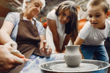 Torunları olan büyükanne çömlekçilikte sürahi yapar