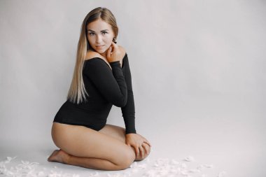 Stüdyoda oturan sarı saçlı zarif bir kadın.