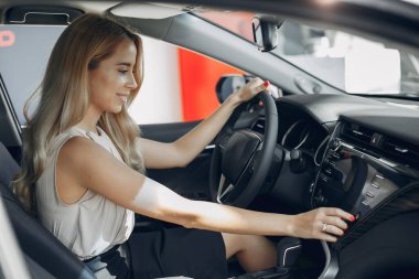 Bir araba galerisinde şık ve zarif bir kadın.