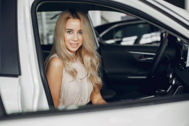 Bir araba galerisinde şık ve zarif bir kadın.