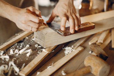 Tahtayla çalışan yakışıklı marangoz.