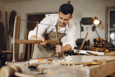 Tahtayla çalışan yakışıklı marangoz.