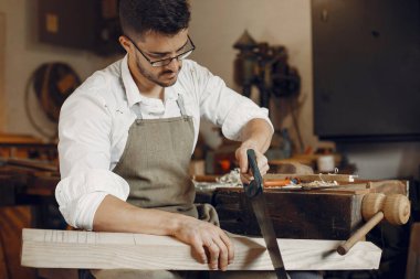 Tahtayla çalışan yakışıklı marangoz.