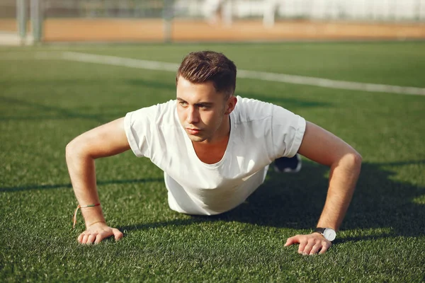 Handsome man training in a summer park — Stock Photo, Image