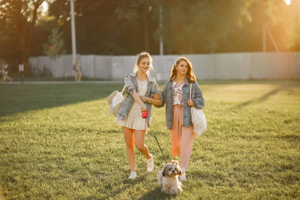 Dos chicas bañándose en un parque con un perrito —  Fotos de Stock