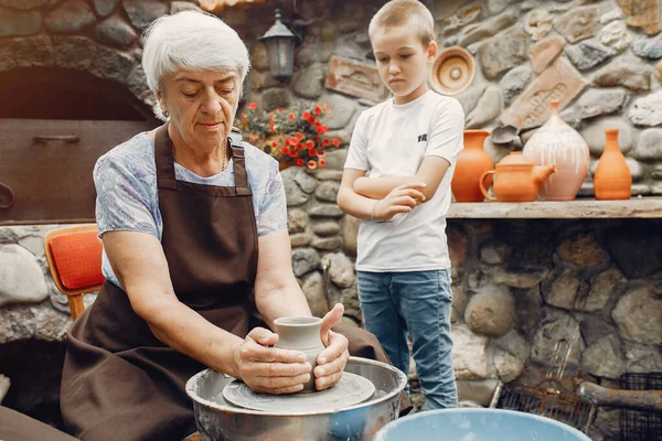 Бабуся з онуками робить глечики в кераміці — стокове фото
