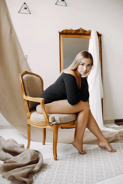 Elegante donna con capelli biondi seduta in uno studio — Foto Stock
