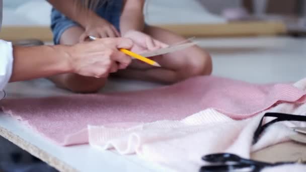 Le mani femminili tengono il cartone e la matita in fabbrica di abbigliamento — Video Stock